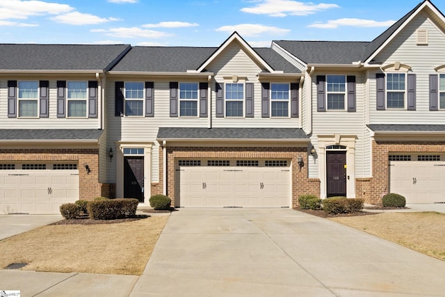 multi unit property featuring driveway, brick siding, and an attached garage