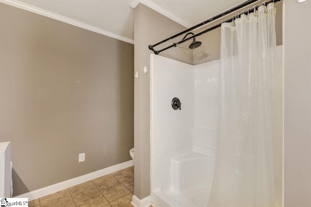 full bathroom featuring crown molding, a shower stall, a textured ceiling, tile patterned flooring, and baseboards