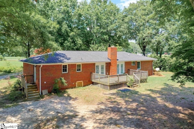 back of property featuring a wooden deck, a chimney, and brick siding