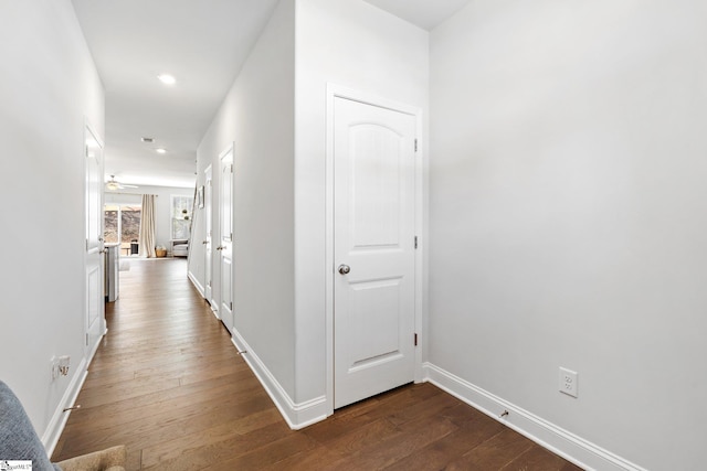 hallway with dark wood-style flooring, recessed lighting, and baseboards