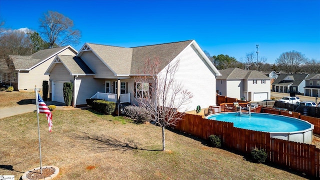 exterior space with a lawn, a residential view, fence, and a fenced in pool