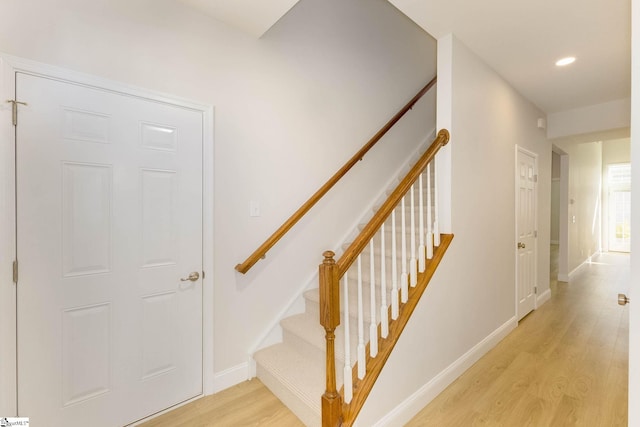 staircase with recessed lighting, wood finished floors, and baseboards