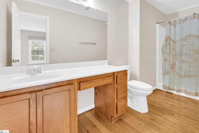 bathroom featuring toilet, ornamental molding, wood finished floors, and vanity