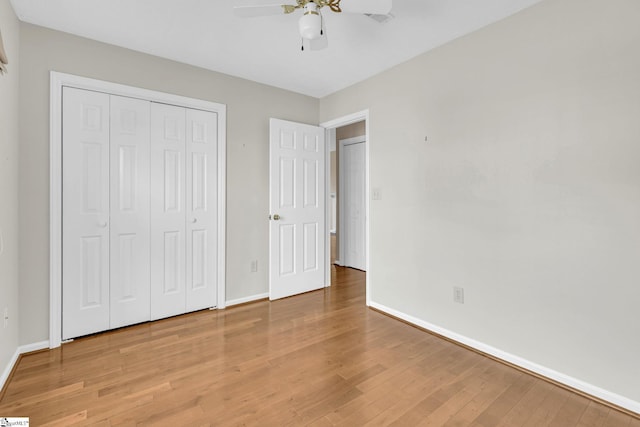 unfurnished bedroom featuring a closet, ceiling fan, baseboards, and wood finished floors