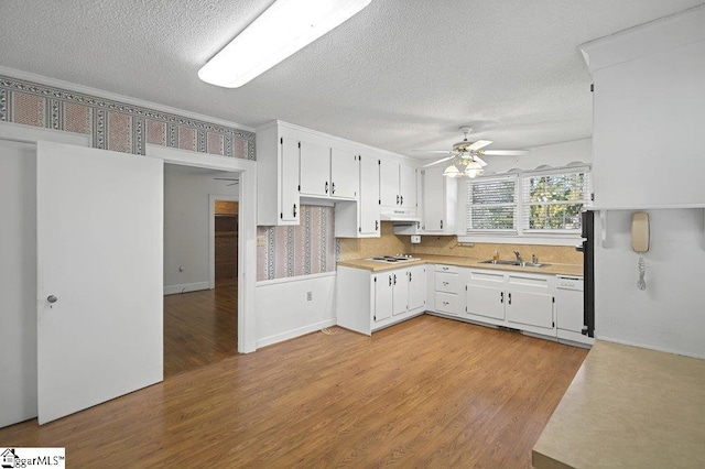 kitchen featuring light countertops, white appliances, light wood-type flooring, and white cabinets