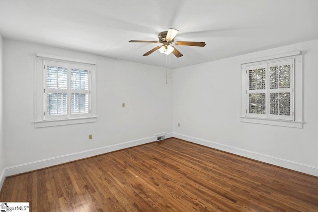 unfurnished room featuring a ceiling fan, wood finished floors, visible vents, and baseboards