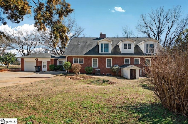 new england style home with a garage, concrete driveway, brick siding, and a front yard