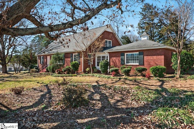 cape cod home featuring brick siding