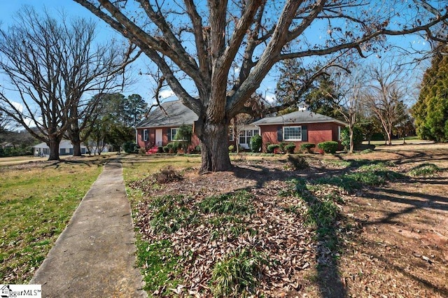 view of front of home featuring a front yard and brick siding