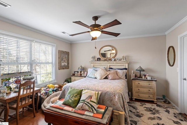 bedroom featuring ornamental molding, visible vents, ceiling fan, and wood finished floors