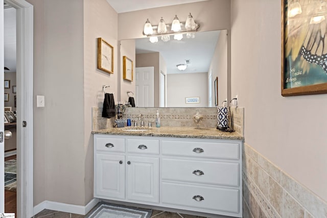 bathroom with tasteful backsplash, vanity, and baseboards