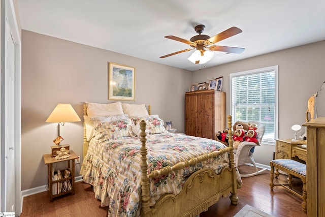 bedroom featuring ceiling fan, baseboards, and wood finished floors