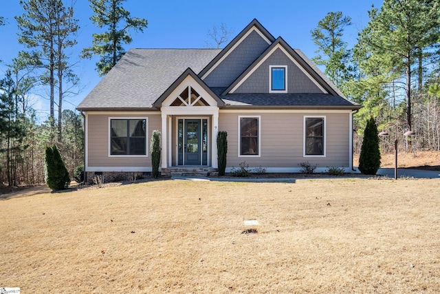 view of front of house with crawl space, a front lawn, and roof with shingles