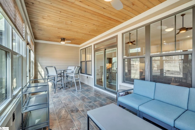 unfurnished sunroom featuring wood ceiling and a ceiling fan