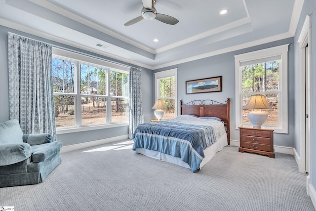 carpeted bedroom with visible vents, a raised ceiling, and crown molding