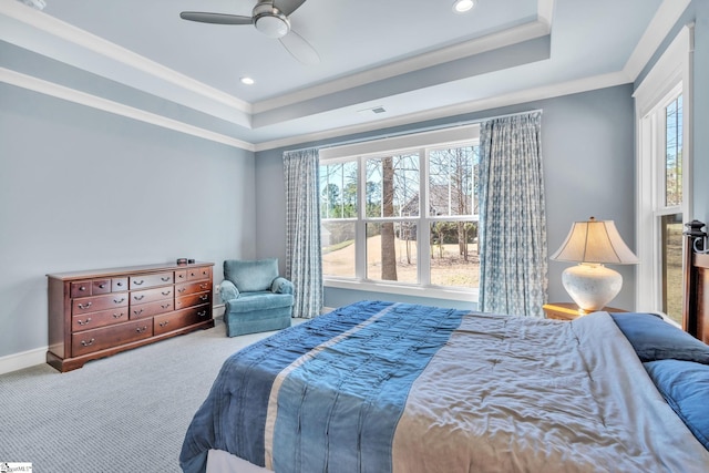 carpeted bedroom with ornamental molding, a raised ceiling, and multiple windows