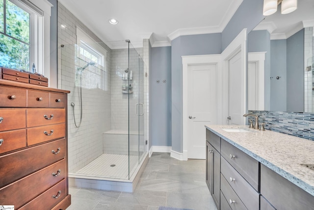 bathroom featuring tasteful backsplash, ornamental molding, a stall shower, vanity, and baseboards