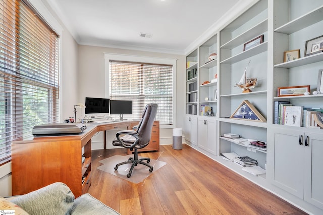 office featuring visible vents, light wood-style flooring, and a healthy amount of sunlight