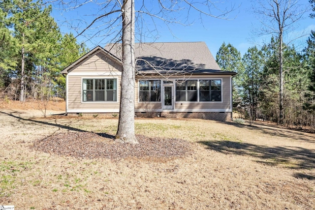 rear view of house featuring crawl space and a lawn