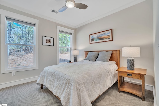 carpeted bedroom with baseboards, a ceiling fan, visible vents, and crown molding