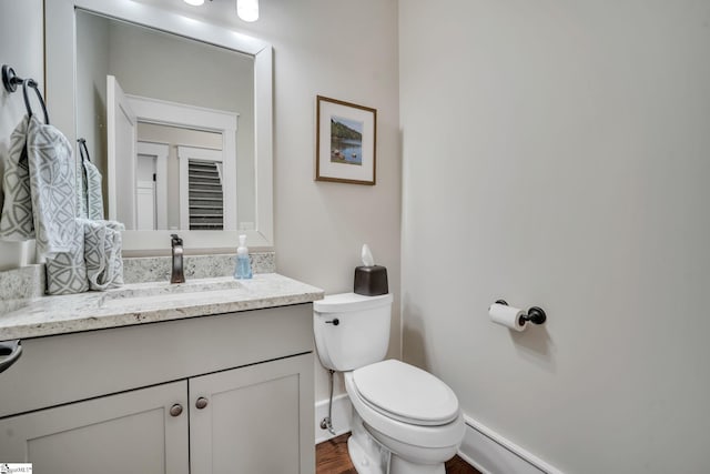 bathroom with vanity, toilet, and wood finished floors