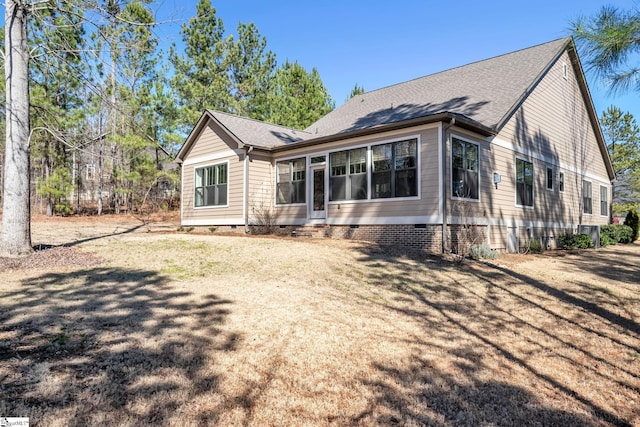 rear view of house featuring crawl space, a lawn, and roof with shingles