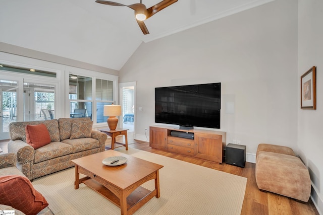 living area with baseboards, high vaulted ceiling, a ceiling fan, and light wood-style floors