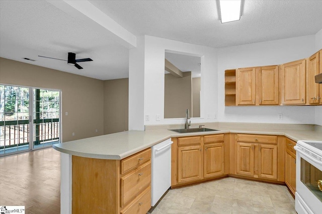 kitchen with white appliances, visible vents, a peninsula, light countertops, and a sink