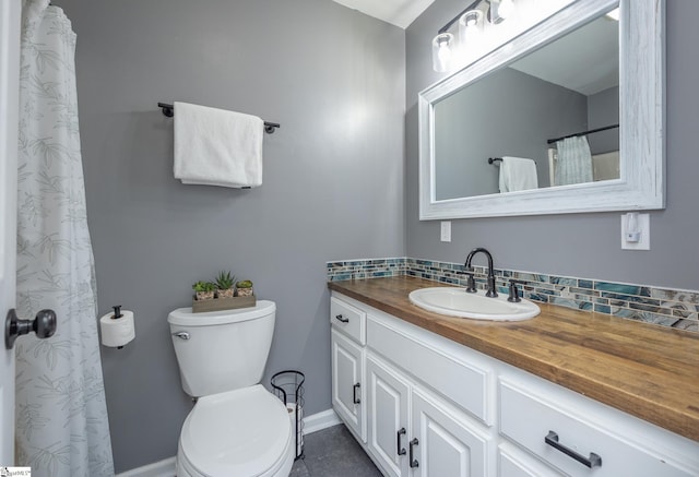 full bath featuring toilet, backsplash, vanity, and baseboards