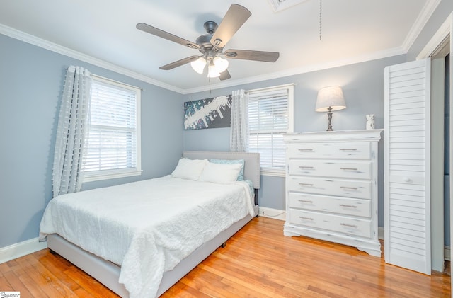 bedroom featuring baseboards, crown molding, and light wood finished floors