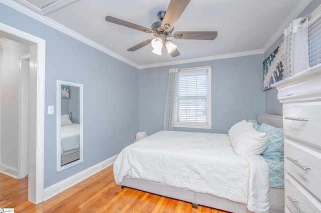 bedroom with a ceiling fan, crown molding, baseboards, and wood finished floors