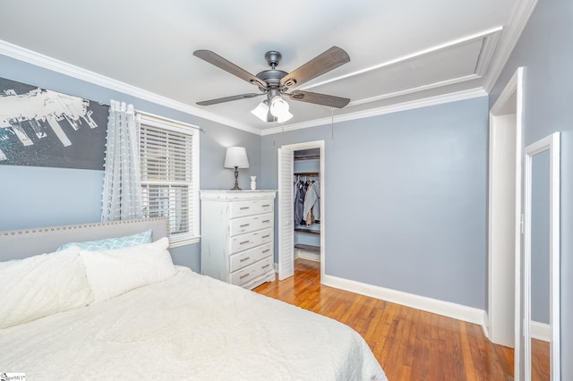 bedroom featuring baseboards, ornamental molding, ceiling fan, and wood finished floors