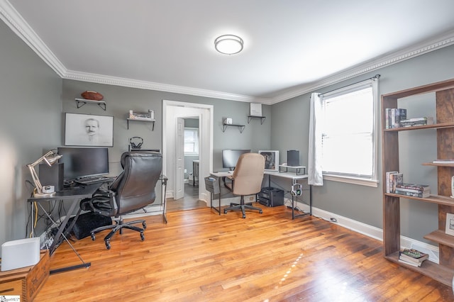 home office featuring ornamental molding, plenty of natural light, light wood-style floors, and baseboards