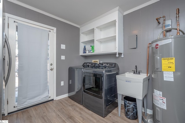 clothes washing area with crown molding, light wood-style floors, electric water heater, laundry area, and independent washer and dryer