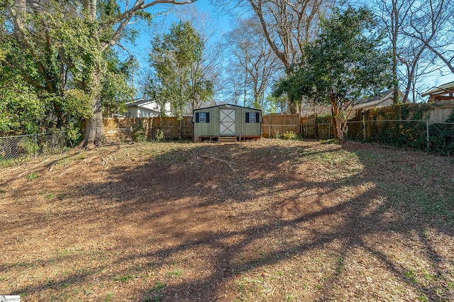 view of yard with a storage shed, a fenced backyard, and an outdoor structure