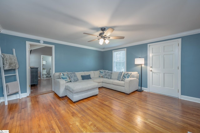 living room with crown molding, baseboards, ceiling fan, and wood finished floors