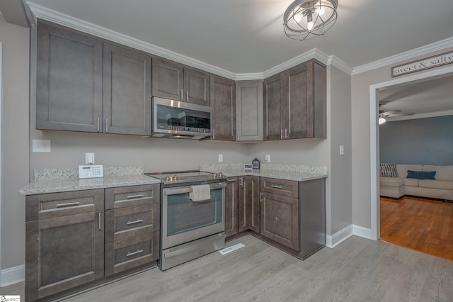 kitchen featuring light stone counters, light wood-style flooring, baseboards, appliances with stainless steel finishes, and crown molding