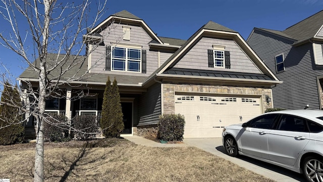 view of front of house with a garage, concrete driveway, stone siding, metal roof, and a standing seam roof