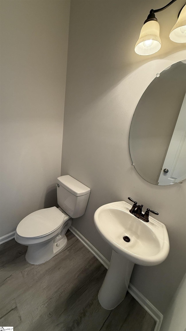 bathroom featuring toilet, baseboards, and wood finished floors