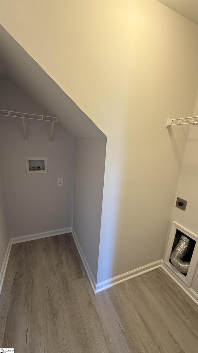 clothes washing area featuring washer hookup, electric dryer hookup, wood finished floors, laundry area, and baseboards