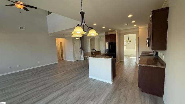 kitchen featuring visible vents, open floor plan, stainless steel fridge with ice dispenser, light wood finished floors, and pendant lighting