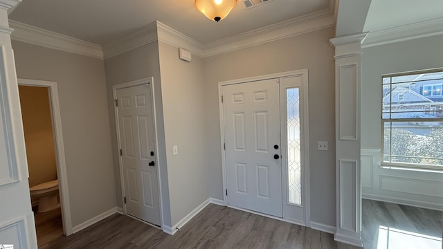 entryway with dark wood-style floors, ornamental molding, baseboards, and ornate columns