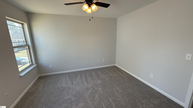 unfurnished room with ceiling fan, dark colored carpet, and baseboards