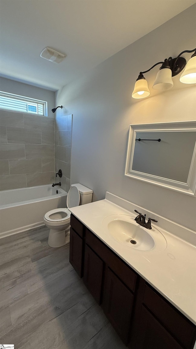 full bathroom with wood finished floors, vanity, toilet, and shower / bathtub combination