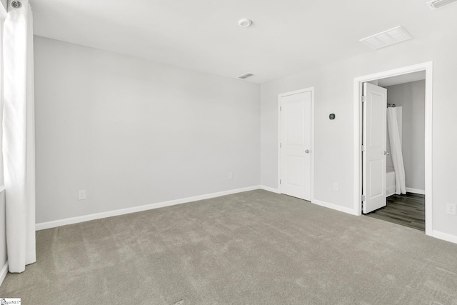 unfurnished room with visible vents, baseboards, and carpet flooring