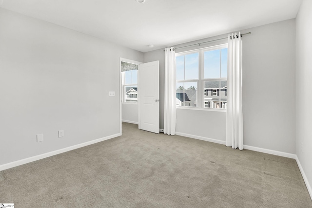 empty room with baseboards and carpet