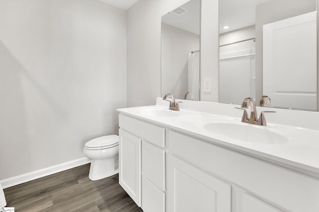 full bath featuring wood finished floors, toilet, baseboards, and a sink