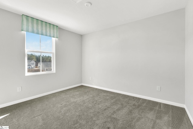 empty room featuring baseboards and carpet floors