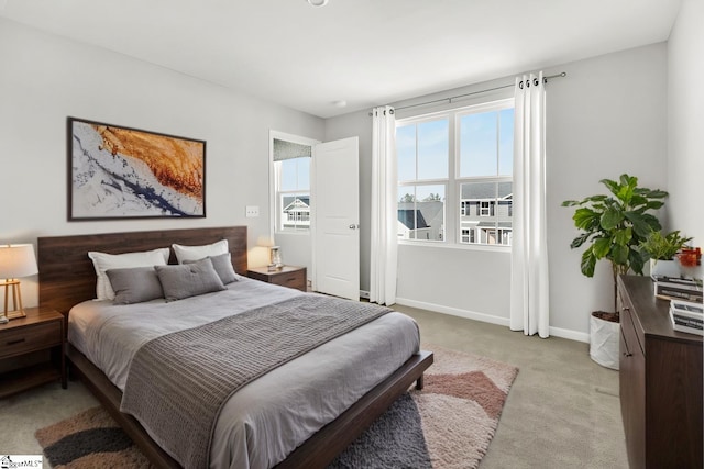 bedroom featuring light colored carpet and baseboards