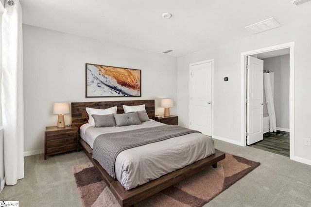 bedroom with visible vents, light carpet, and baseboards